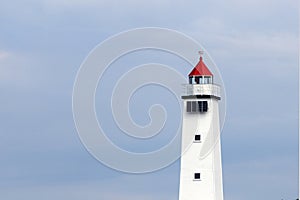 White lighthouse against blue sky