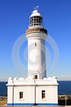 White lighthouse by blue sky and sea