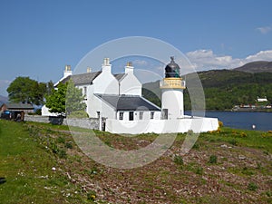 White lighthouse and keeper`s cottages