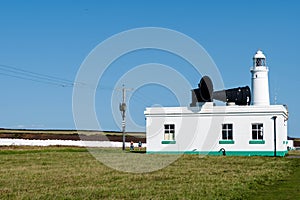 White lighthouse, Nash Point, Vale of Glamorgan, Wales. ship horn in foreground