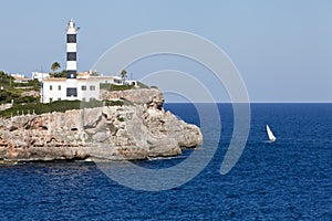 White lighthouse on rocks in the sea ocean water sky blue