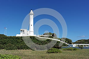 The white lighthouse stand on green hill