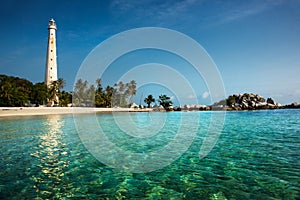 White lighthouse standing on an island in Belitung at daytime.