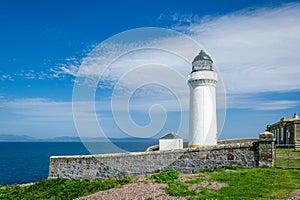 White lighthouse tower and stone fence