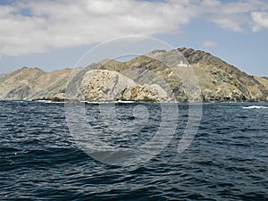 White lightouse on the channel of bay bahia magdalena on Marguerite island coast over the pacific ocean volcanic rocks in baja