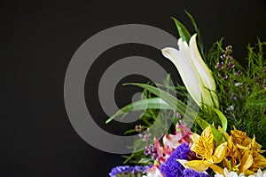 White lilyes, yellow and pink orchids, branch of lilac, chrysanthemums in the spring  tender bouquet on the background with black