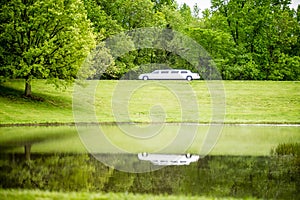 White limo reflecting in lake