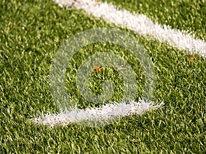 White line marks painted on artificial green turf background. Playfield border.