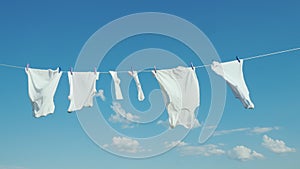 White linen dries on the rope against the blue sky