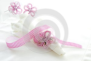 White linen serviette with pink beaded napkin ring