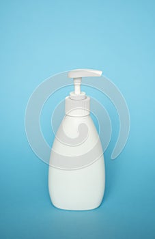 White liquid container, Cosmetic plastic bottle for gel, lotion, cream, shampoo, bath foam with dispenser pump on blue