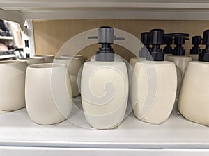 White liquid soap or shampoo dispenser on a shelf lying in a stack in a store