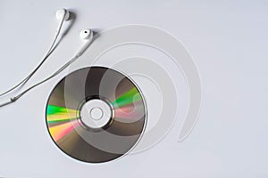 White little headphones are on CD-ROM on white background