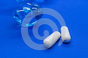 White long health capsule pills on blue background