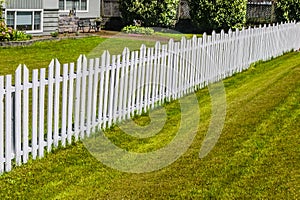 White long wooden fence along the front yard of residential house