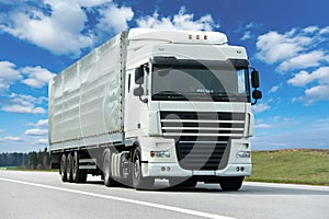 White lorry with grey trailer over blue sky