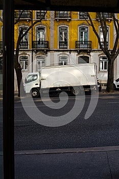 White lorry parked in front of historic building
