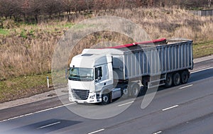 White lorry with trailer in motion on the motorway