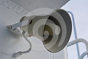 White loudspeaker on a white background. Signs of paint at the wall, nostalgic light around. Retro technology, horn speaker