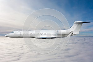 White luxury business jet flies in the air above the clouds