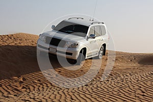 White luxury car is in the sand