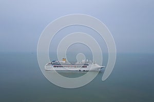 White luxury cruise ship docked in beautiful Caribbean sea close