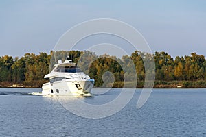 White luxury yacht in motion on the Dniepr River, side view.