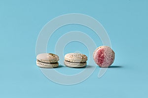 White macarons cake with colorful powder, top view, flat lay, sweet macaroon on blue background.
