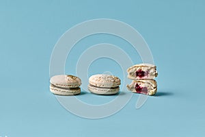 White macarons cake with colorful powder, top view, flat lay, sweet macaroon on blue background.