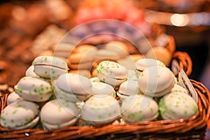White Macron with green caramel sugar display for sale in Barcelona market, Spain, Slective focus photo