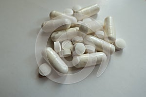 White magnesium citrate capsules and vitamin K tablets in a heap