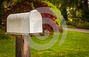 White mailbox in a rural setting in background. Retro style postbox at roadside