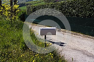 A white mailbox on the side of the road Pesaro, Italy