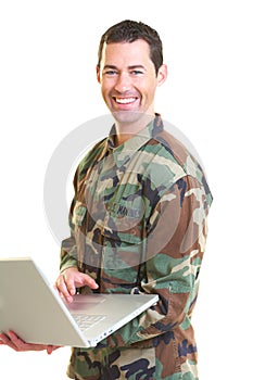White male in army uniform on lap top smiling