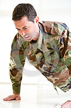 White male in army uniform straining doing a push up