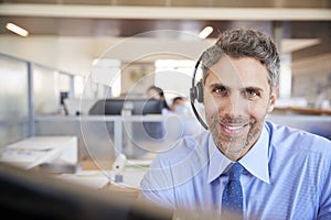 White male call centre worker smiling to camera