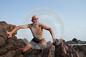 The white man climbed to the top of the cliff. He is strong and happy