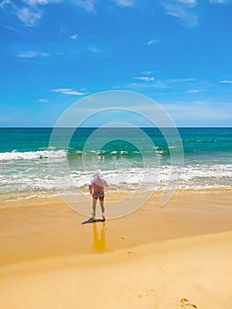 White man is running across the sand into the sea with waves. Concept of a long-awaited vacation