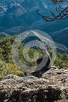 White man sitting on mountain top in the Sierra de Cazorla.