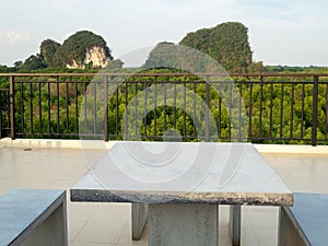 White marble bench table desk and marble chair on roof top with mountain hill and green natural mangrove view