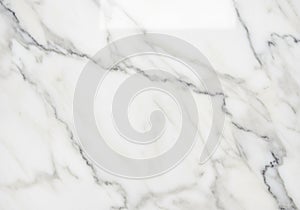 White marble surface featuring subtle gray veining patterns. The texture is smooth and polished,
