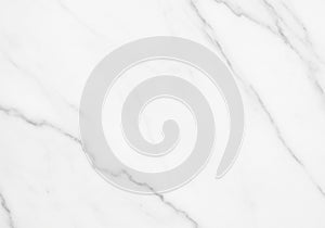 White marble surface featuring subtle gray veining patterns. The