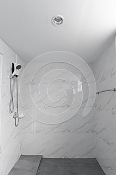 White marble tile wall and gray tile flooring bathroom in natural light scene
