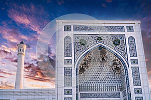 white marble wall decorated uzbek ornaments and minaret of modern Islamic Masjid Minor Mosque in Tashkent in Uzbekistan