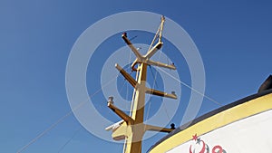 white marine radar rotates on yellow mast of ship traveling on water surface on voyage. Rotating X band marine radar