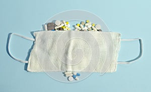 White mask on the pills. Pills laying in a heart shape on blue background