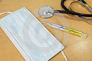 White mask, stetoscope and thermometer