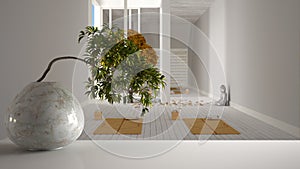 White mat table shelf with round marble vase and potted bonsai, green leaves, over yoga studio, space with mats and accessories,