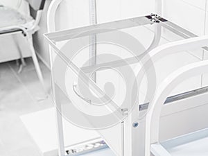 White medical empty operation small table bedside with glass shelf in white interior, doctors office. Workplace