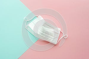 White medical mask. Sky blue and pink background. Face mask protection against pollution, virus, flu, coronavirus